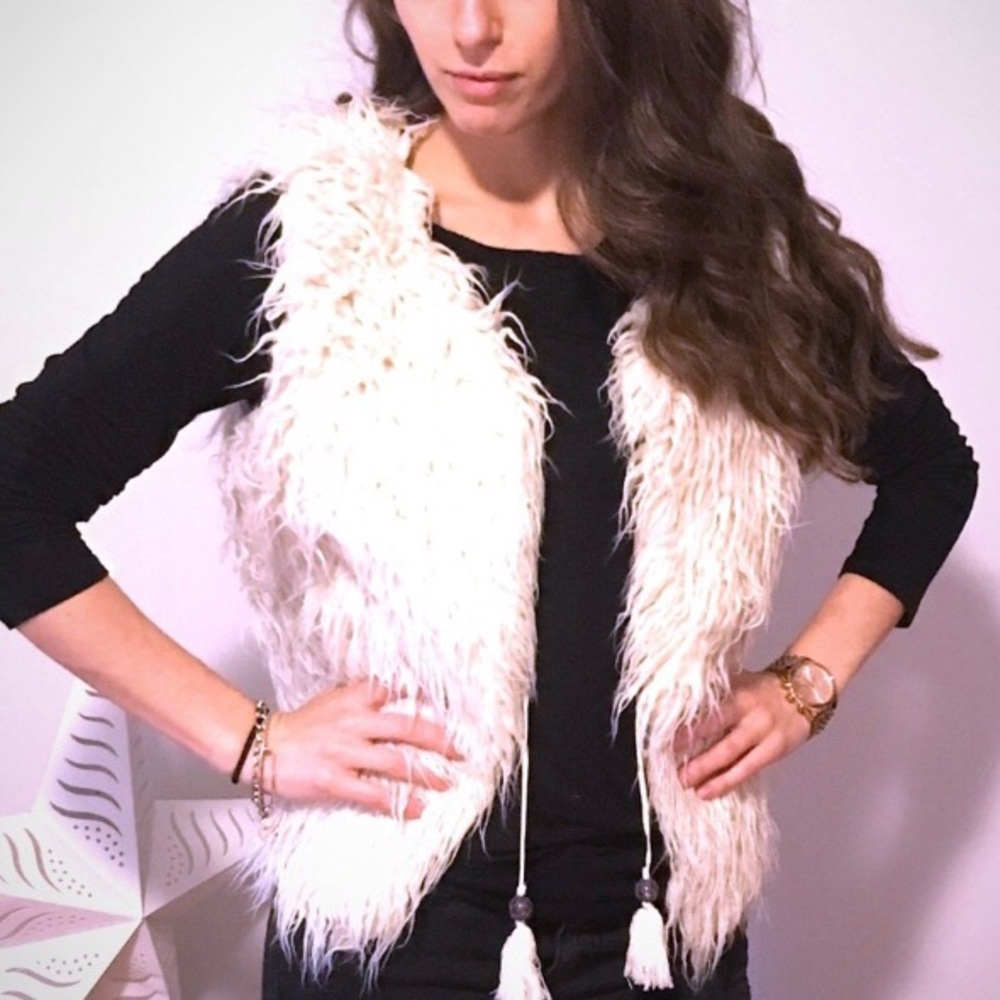 White furry vest with tassels.